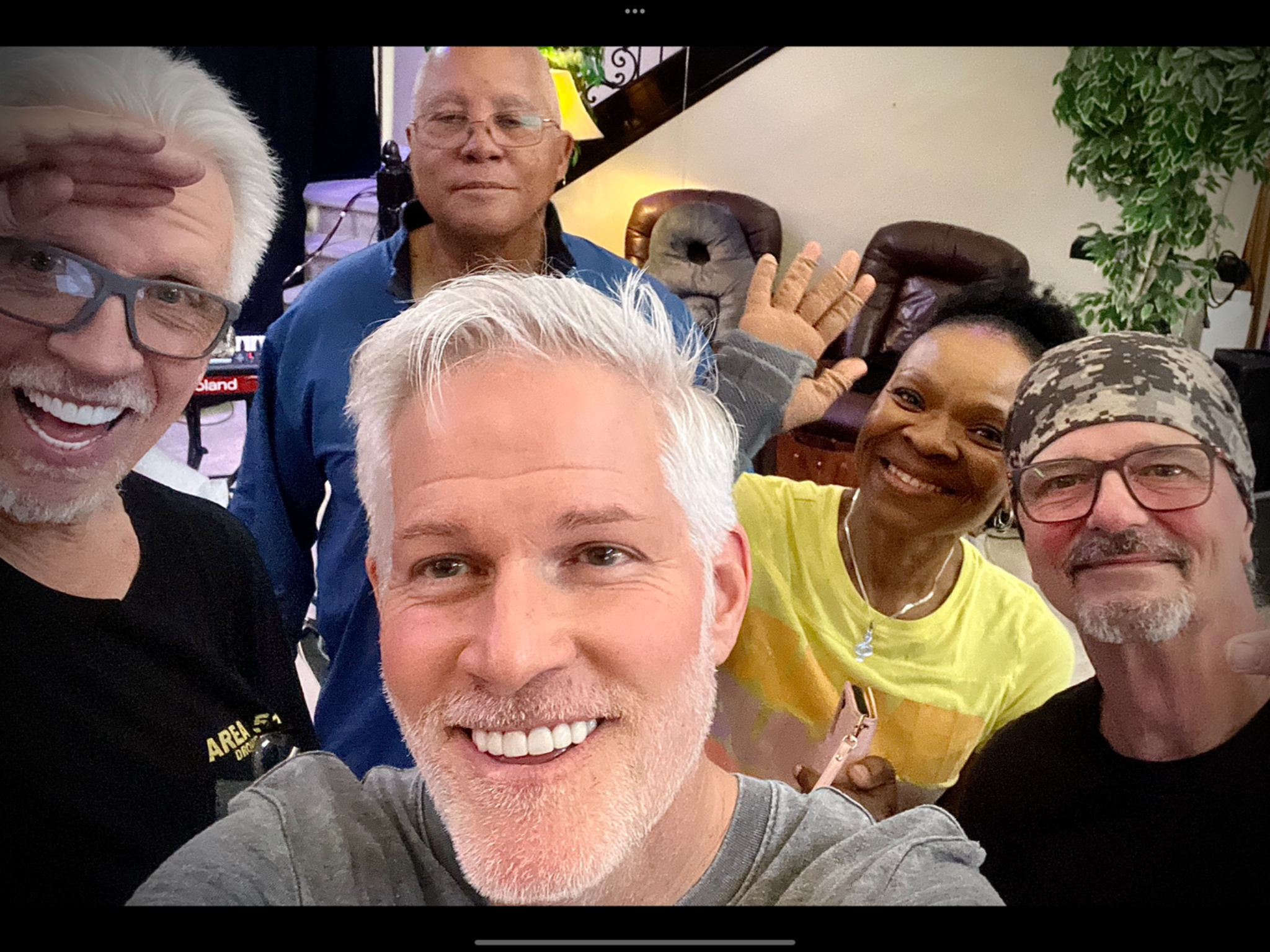 Five people posing together indoors.